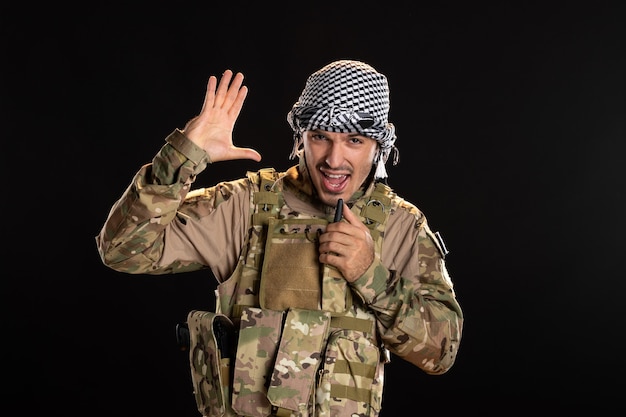 ラジオセットの黒い壁を通して話している軍服を着たパレスチナの兵士