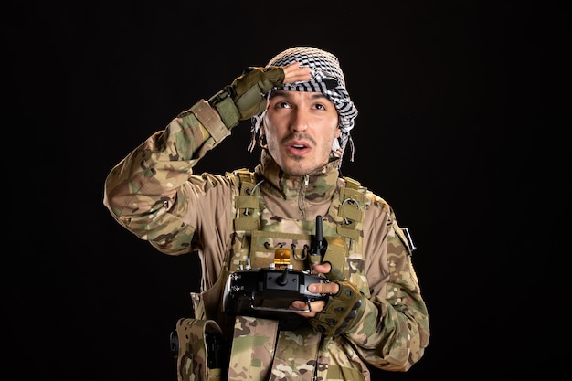 Palestinian soldier using remote controller on a black wall