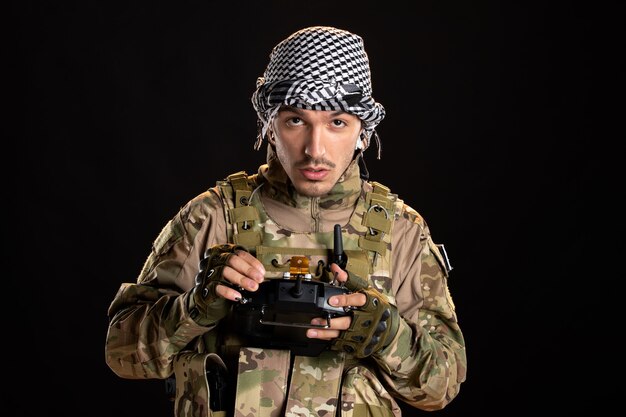 Палестинский солдат с помощью пульта дистанционного управления на черной стене