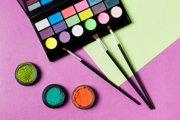 Palette of colorful eyeshadows and cosmetic brushes