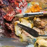 Free photo palette knife mixing paint near brush