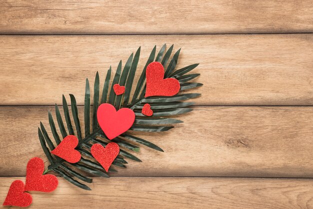 Free photo palm twig and row of ornament hearts