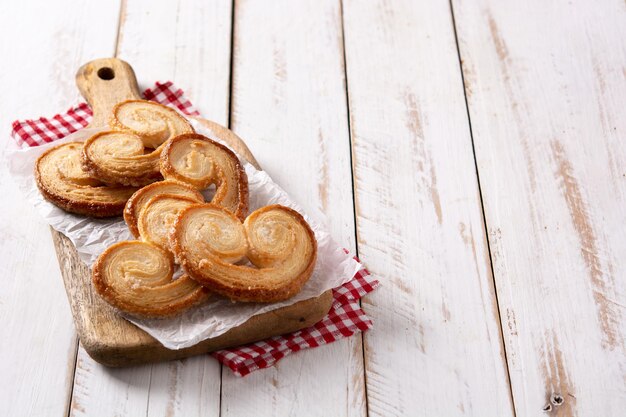 Palmier puff pastry in plate on white wooden table