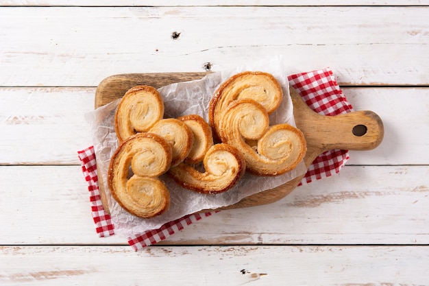 Palmier puff pastry in plate on white wooden table