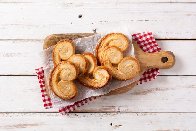 Palmier puff pastry in plate on white wooden table