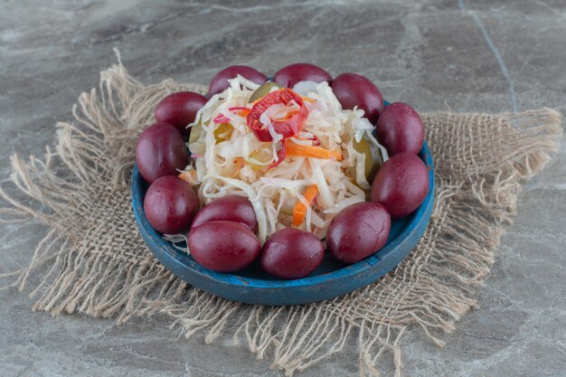 Palms around sauerkraut on wooden plate. 