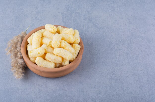 Pampas grass and bowl of corn stick on marble.