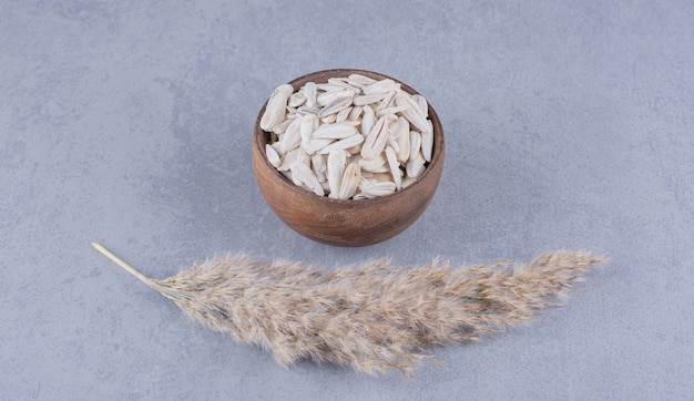 Free photo pampas grass and bowl of sunflower seeds on the marble surface