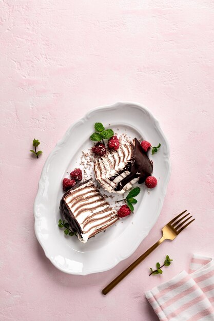 Блинчиковый шоколадный торт с свежими малинами на розовом фоне