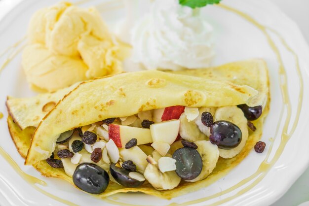 Pancake and fruit with ice cream on table