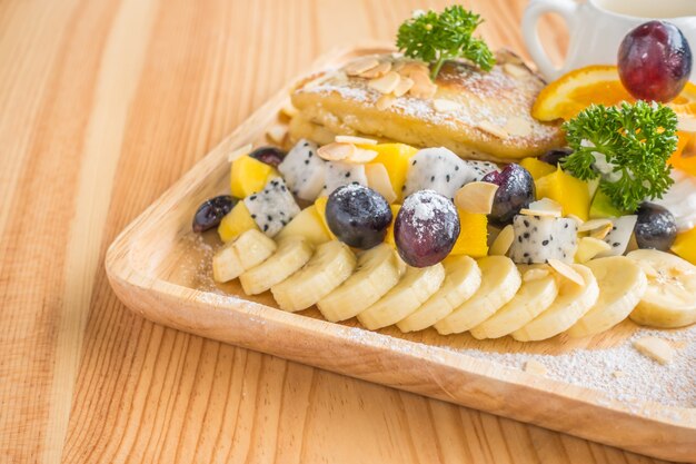 Pancake and fruit with ice cream on table .