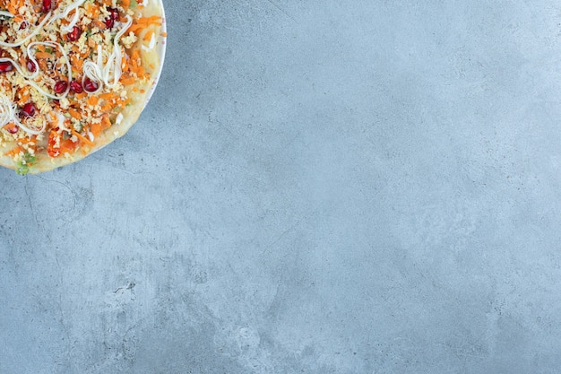 Pancake layer under cheese and walnut salad on marble.