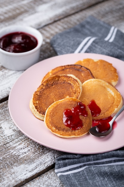 Pancakes on plate for breakfast with jam and spoon