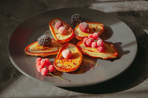 Pancakes in a plate with blackberries and cranberries