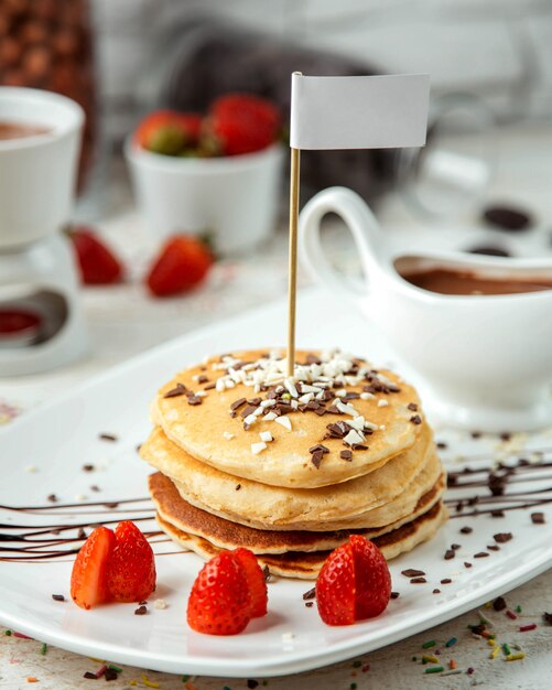Pancakes sprinkled with chocolate and strawberries