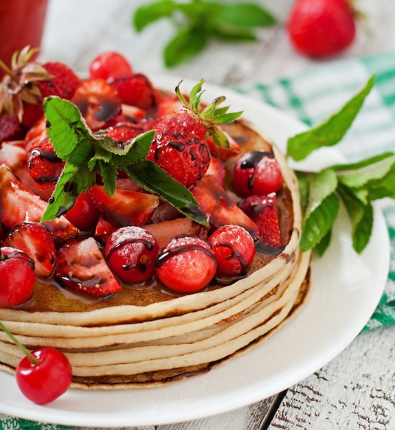 Pancakes with berries and strawberry smoothie in a rustic style