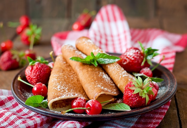 Pancakes with berries and syrup in a rustic style