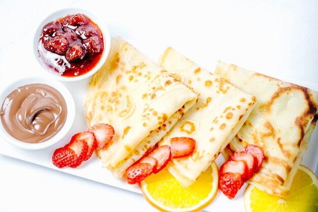 pancakes with jam strawberries and chocolate cream