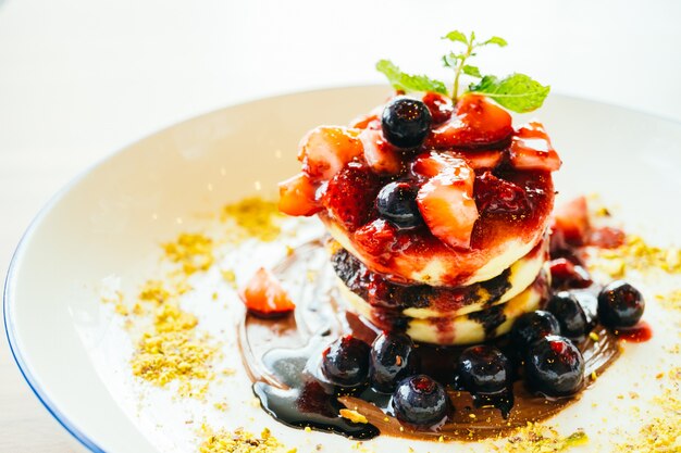 Pancakes with mixed berry fruit in white plate