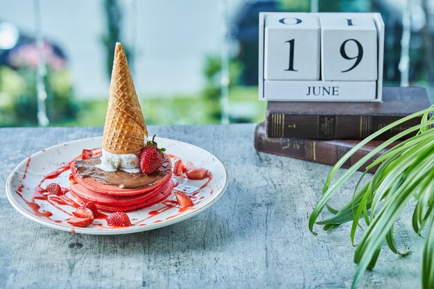 Pancakes with strawberry, ice-cream cone in the white plate 