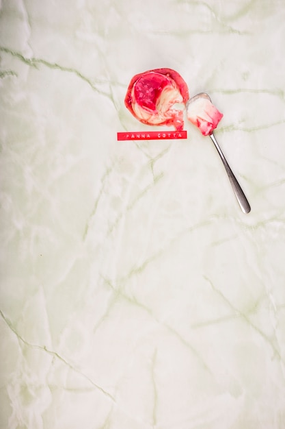 Panna cotta dessert with spoon on marble