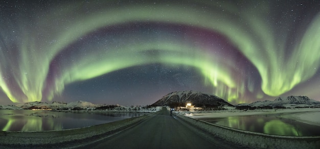 Free photo panorama of colors creating a vault over a bridge surrounded by a winter wonderland