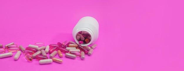 Панорама разноцветные таблетки и капсулы на розовом фоне Premium Фотографии