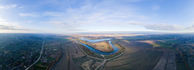 モルドバの自然のパノラマ。ドニエストル川は、地平線に広がる畑である、国道のある村です。ドローンからの眺め