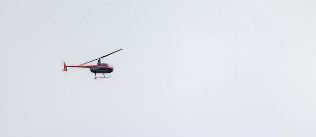 Panoramic shot of a helicopter flying in a cloudy sky