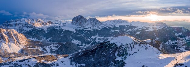 Panoramic shot of mountains covered in snow at sunset