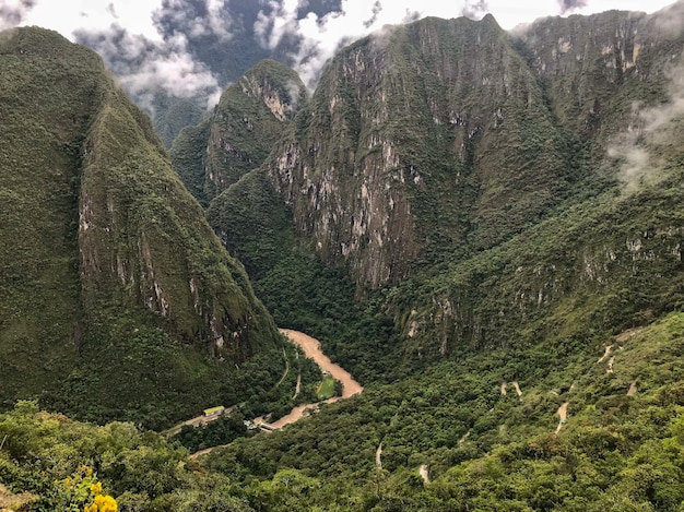 무료 사진 majestic machu picchu의 녹색 산 한가운데에 있는 갈색 강의 파노라마 샷