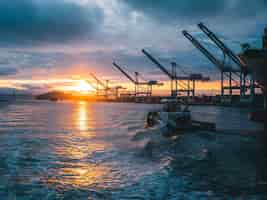 Free photo panoramic shot of oil rigs at sea with a beautiful sunset