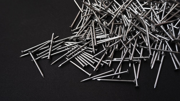 Free photo panoramic shot of a pile of steel nails on a black background