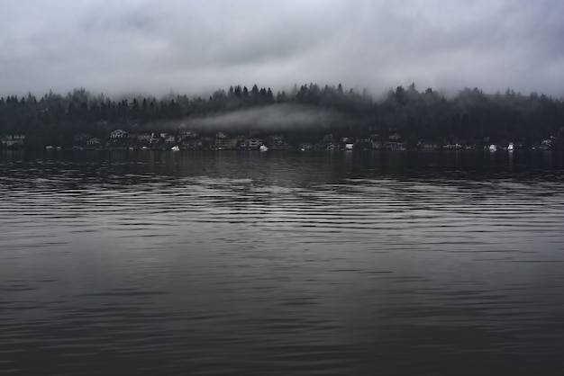 Panoramic shot of a village along the coast with muted colors on a foggy afternoon