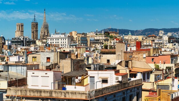 Panoramic view of Barcelona, multiple building's roofs, old cathedrals, Spain