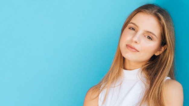 Panoramic view of blonde young woman against blue background