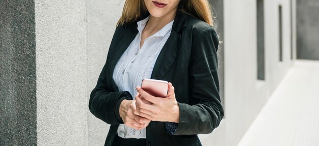 Panoramic view of businesswoman using cell phone at outdoors