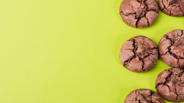 Free photo panoramic view of chocolate cookies on green backdrop