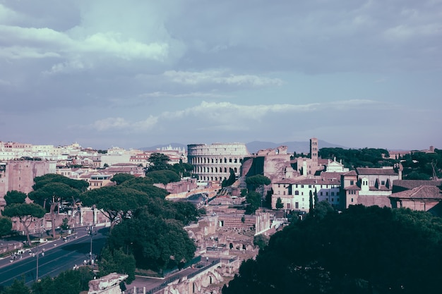 Panoramic view of city rome with roman forum and colosseum from vittorio emanuele ii monument also known as the vittoriano. summer sunny day and dramatic blue sky