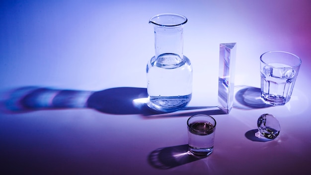 Panoramic view of glass; beaker; prism and diamond with dark shadow on bright background