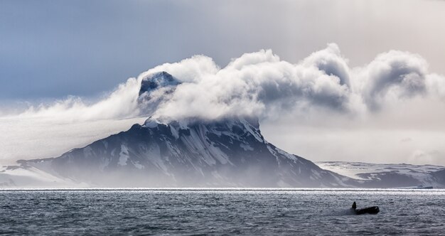 Panoramic view of an iceberg in clouds in Antarctica