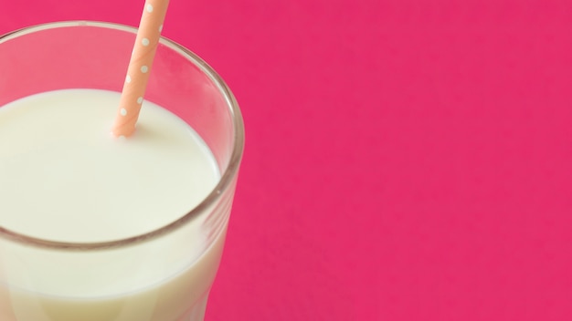 Panoramic view of milk in the glass with drinking straw