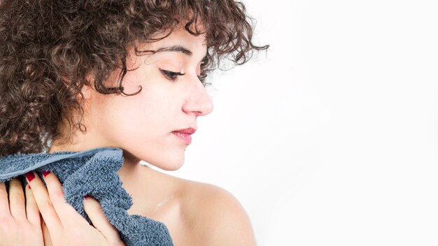 Panoramic view of woman holding napkin looking over the shoulder against white backdrop