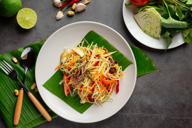 ライスヌードルと野菜のサラダを添えたパパイヤサラダタイの食材で飾られています。