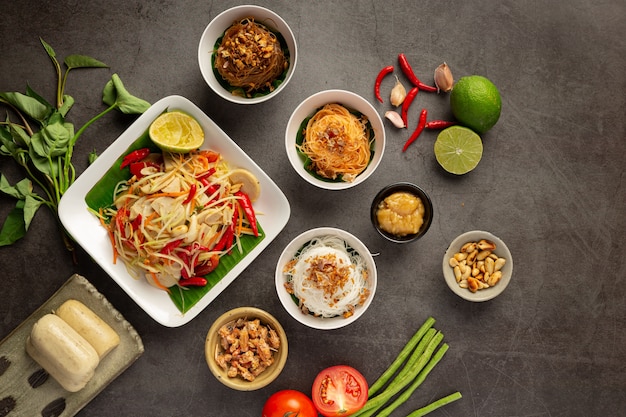 ライスヌードルと野菜のサラダを添えたパパイヤサラダタイの食材で飾られています。