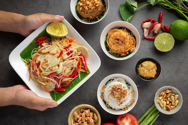 Papaya salad served with rice noodles and vegetable salad Decorated with Thai food ingredients.