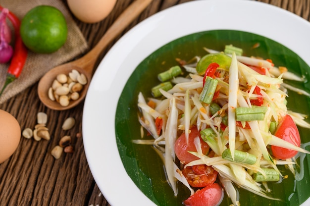 Papaya Salad on a White Plate on a Wooden Table