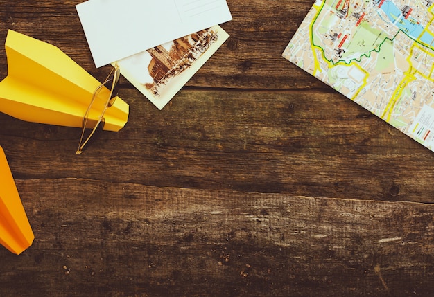 Paper airplane with map on wooden table. travel concept background