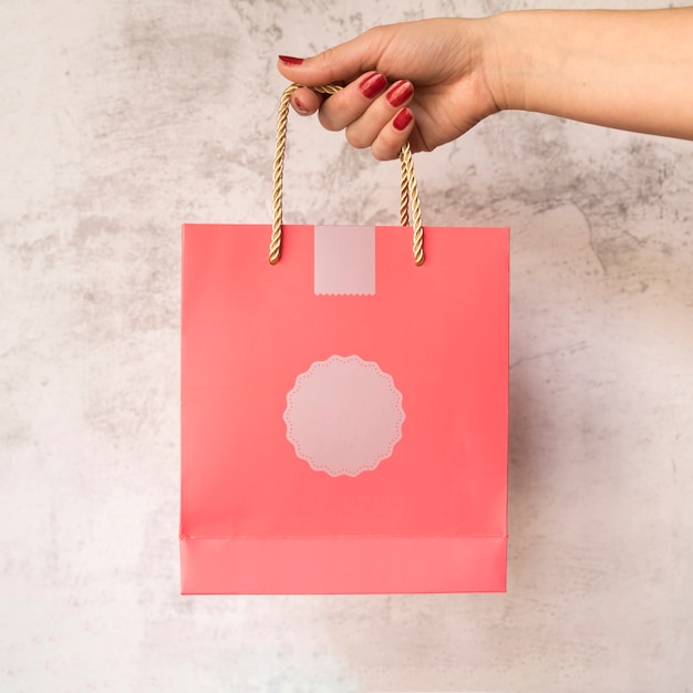 Free photo paper bag hanging from hand