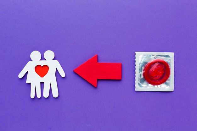 Paper couple next to red condom